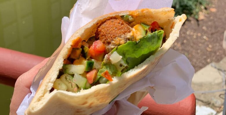 falafel sandwich with lettuce, cucumbers, and wrapping