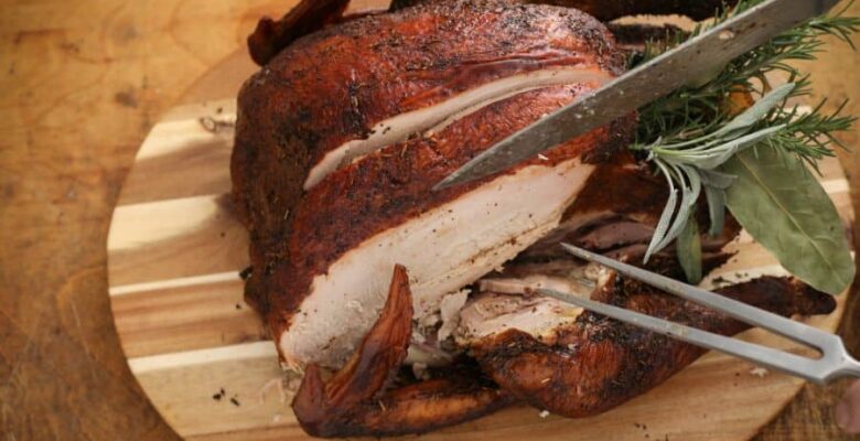 sliced smoked turkey on wooden platter