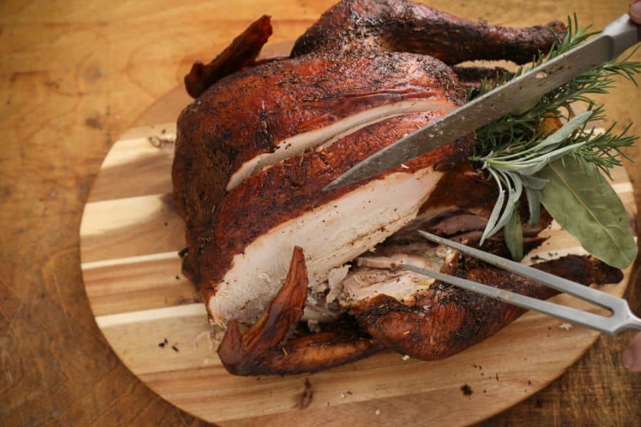 sliced smoked turkey on wooden platter