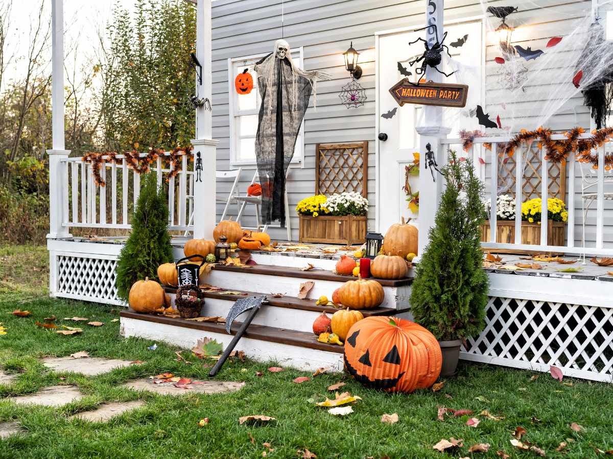 white house with porch decorated with jack o lanterns and other fall decor