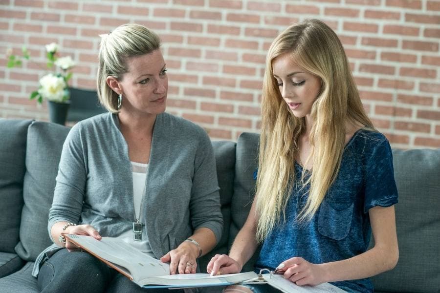 mom and daughter looking through budgeting books