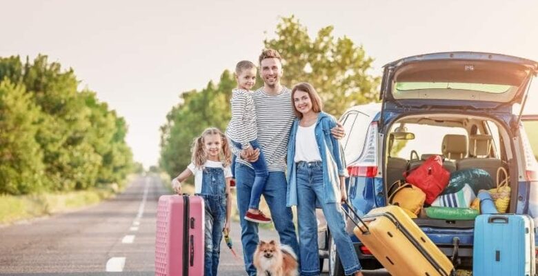 family beside open car with dogs and kids for road trip
