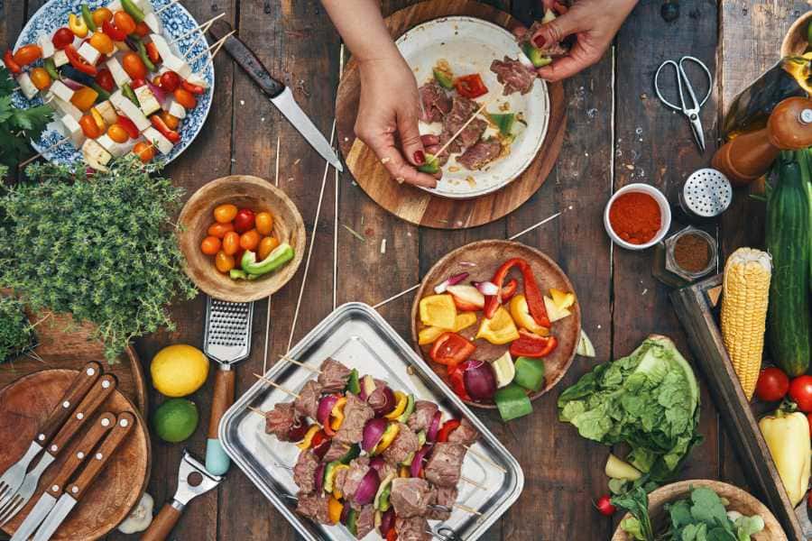 bowls of onions, peppers, cherry tomatoes and meat for shish kebobs