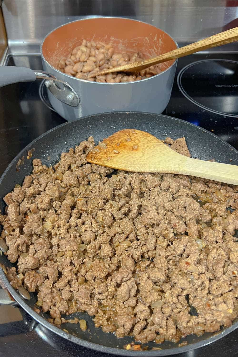 homemade taco meat and taco seasoning in a skillet with homemade beans
