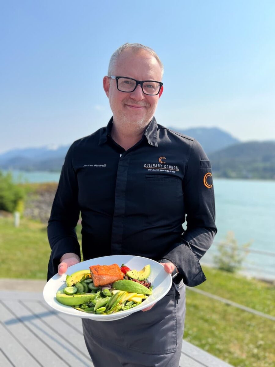 chef holding plate with salmon chopped salad