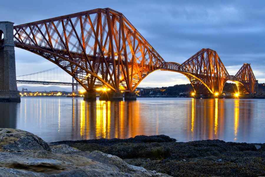 forth bridge lit up at night over the river