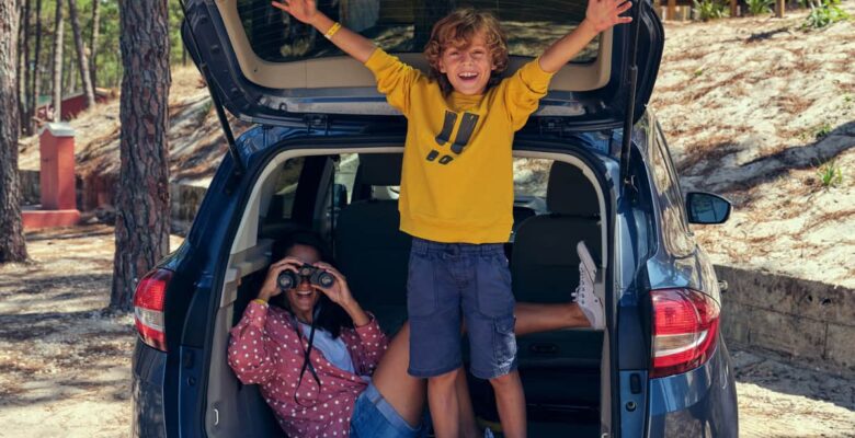 children excited about road trip in car