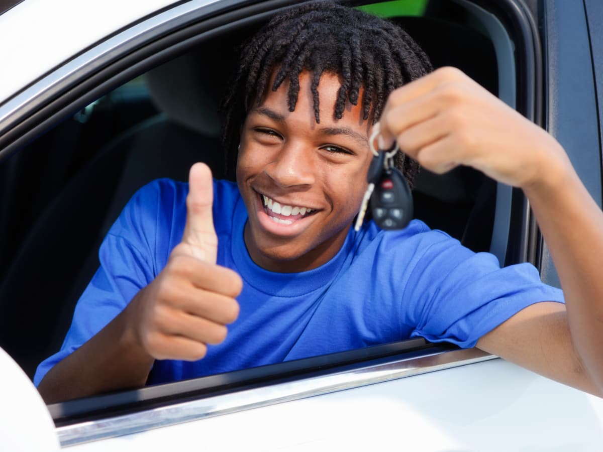 teen boy behind wheel with car keys