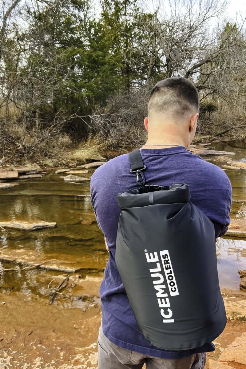 Man with a Icemule soft sided cooler (made in usa) on his back at the lake