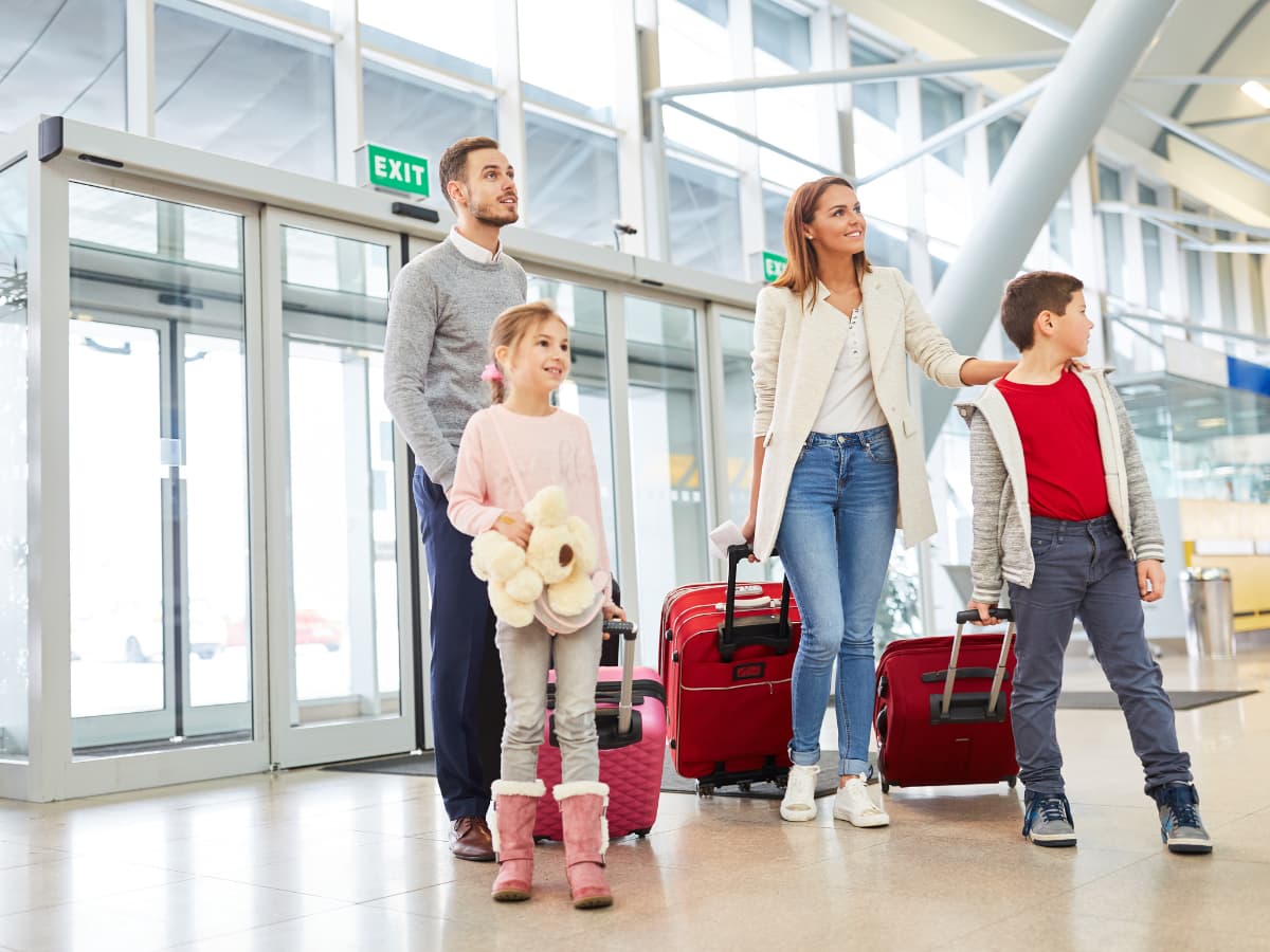 family arriving at airport with luggage