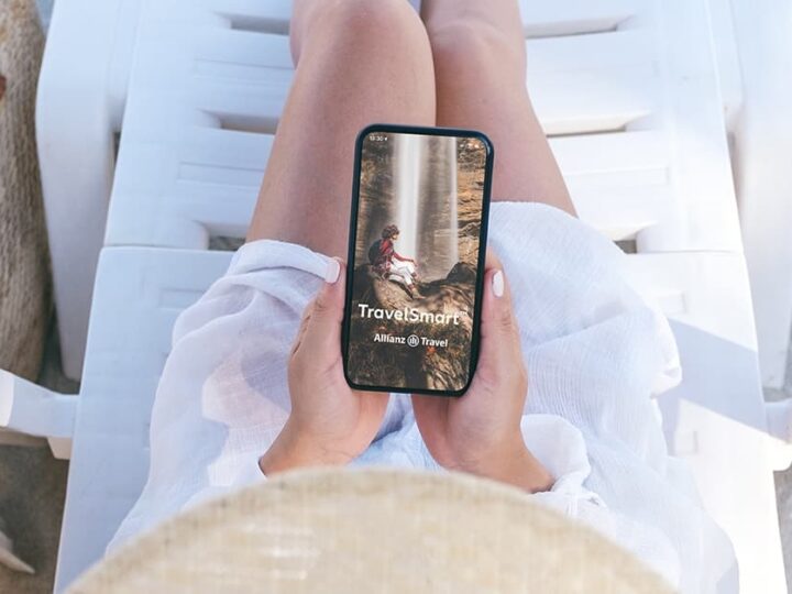 Woman on Allianz travel insurance app on beach