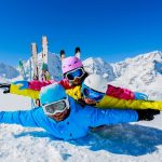 family playing in the snow while skiing