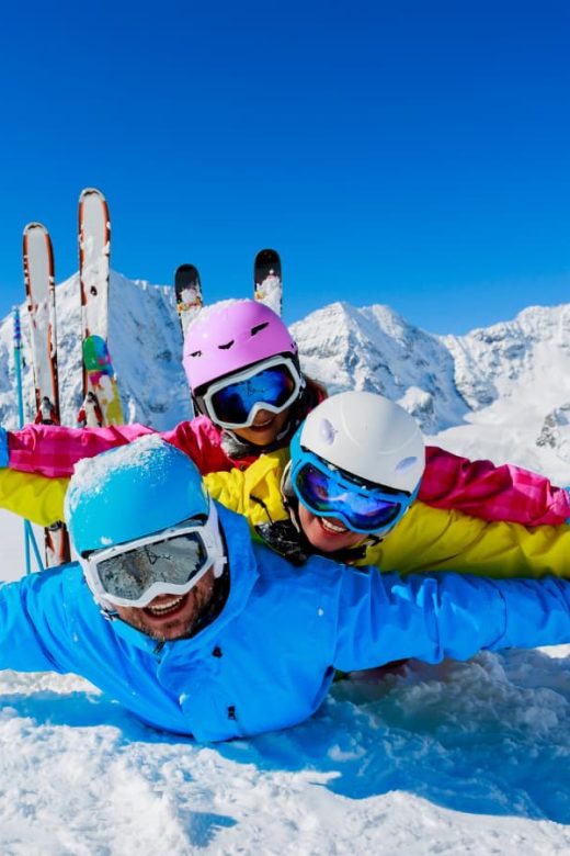 family playing in the snow while skiing