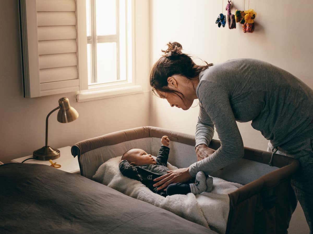 mother soothing baby in cosleeper