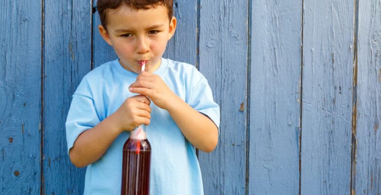 boy drinking soda with a straw