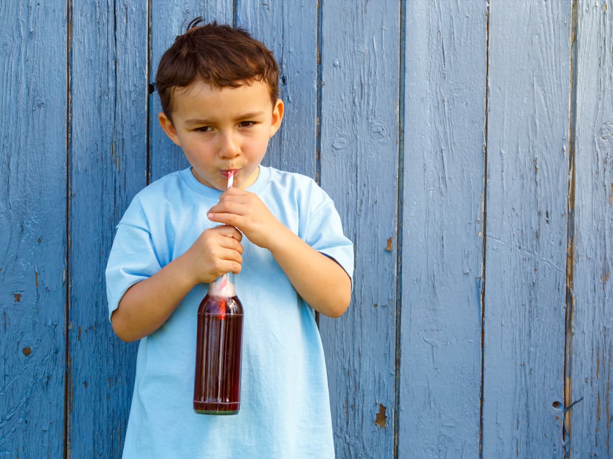 boy drinking soda with a straw