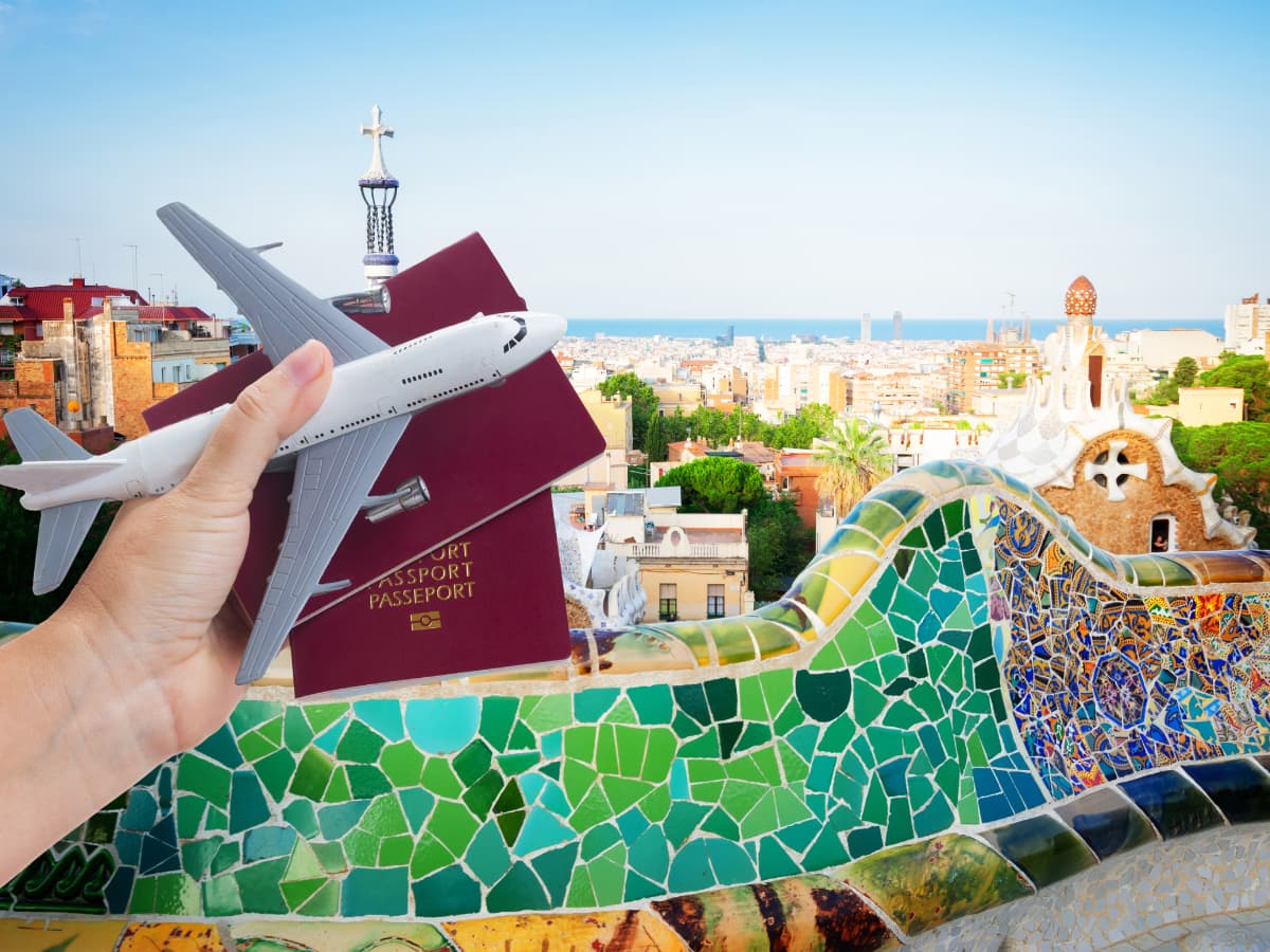 Seville mosaic wall with hand holding passports and toy plane in front of it