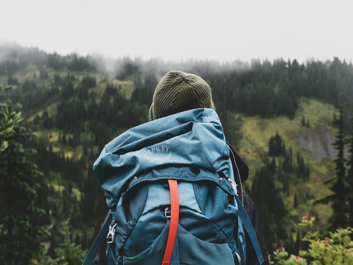 teen with backpack in forest