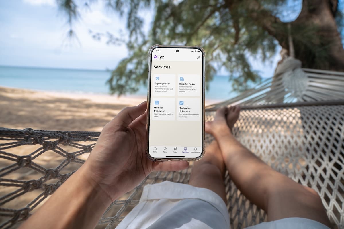 Allyz Travel App in hands of a person at the beach