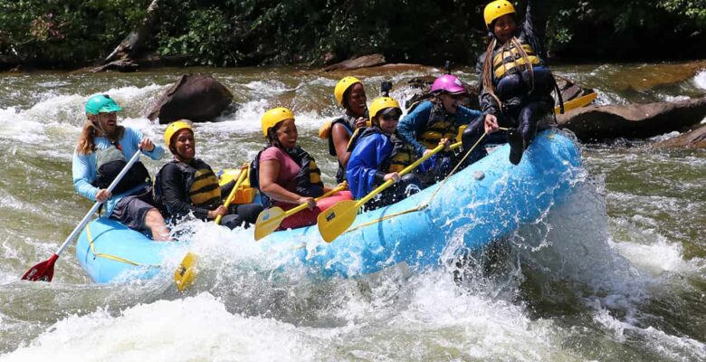 women rafting and one on bow of raft having a great time