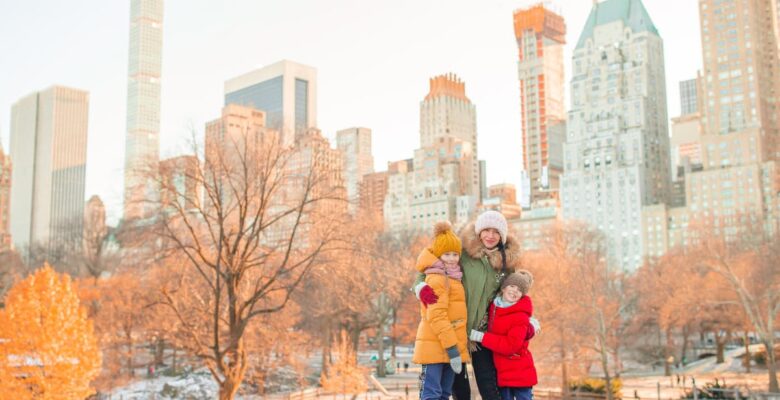family posing for photo in winter coats with city skyline behind