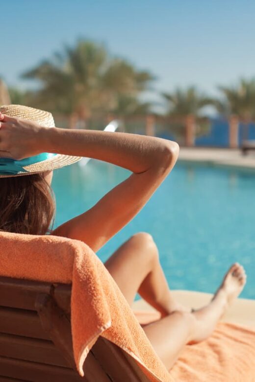 woman relaixng by a swimming pool