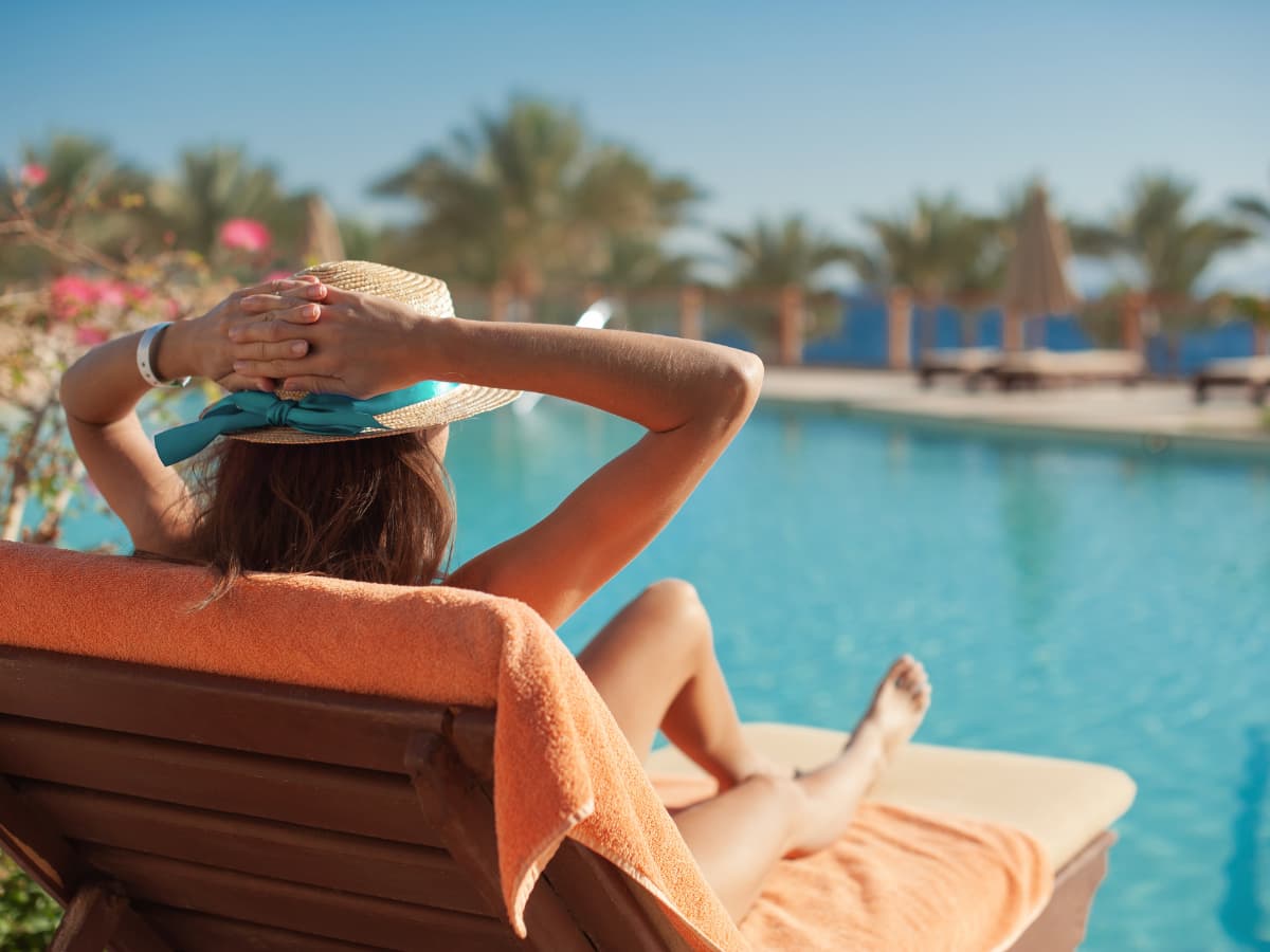 woman relaixng by a swimming pool