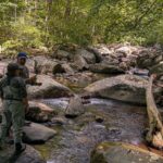 woman and man talking at a stream