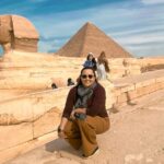 Sphinx and Egyptian pyramid with woman posing in front