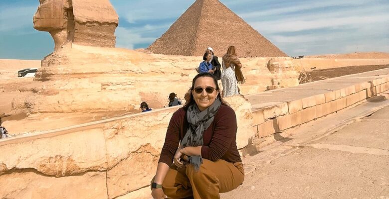 Sphinx and Egyptian pyramid with woman posing in front