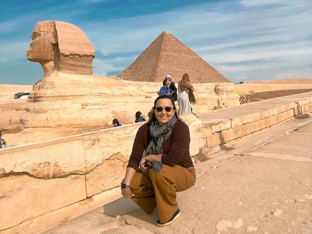 Sphinx and Egyptian pyramid with woman posing in front