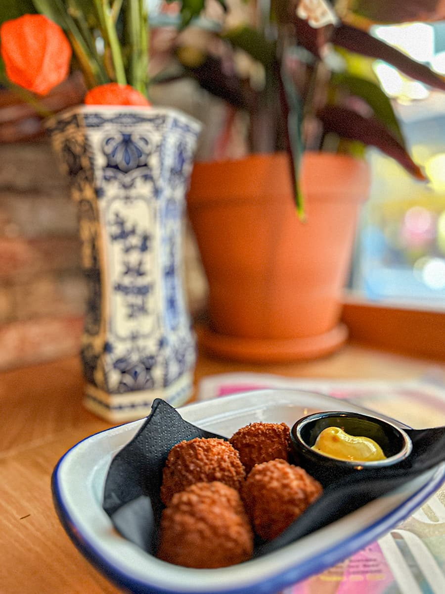 bitterballen in dish in front of flowers and vases