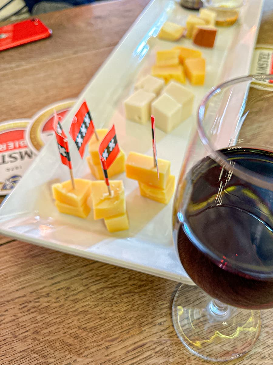 cubed cheese on platter with red wine in glass