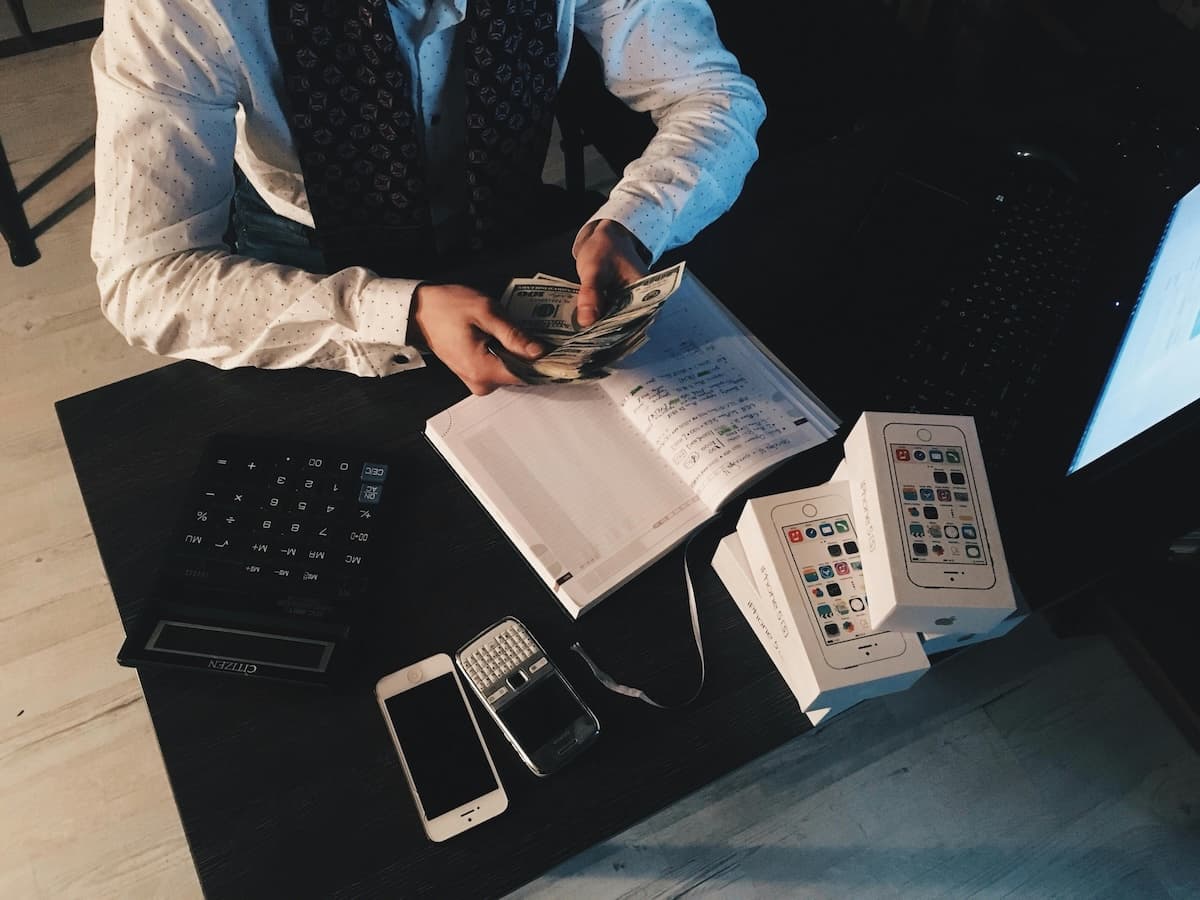 man counting money over books