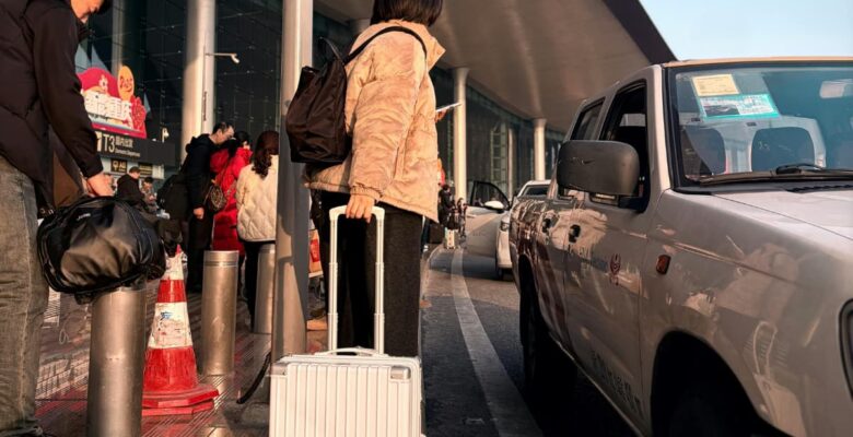 people pulling luggage at airport to get into car