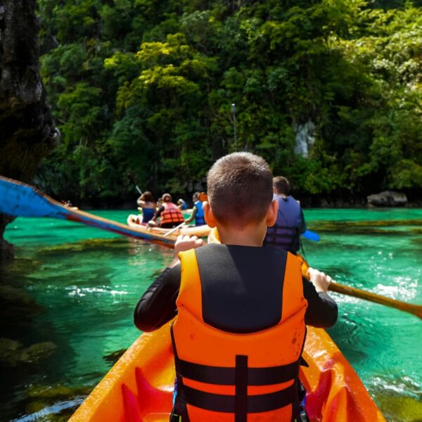 child wearing life jacket in kayak