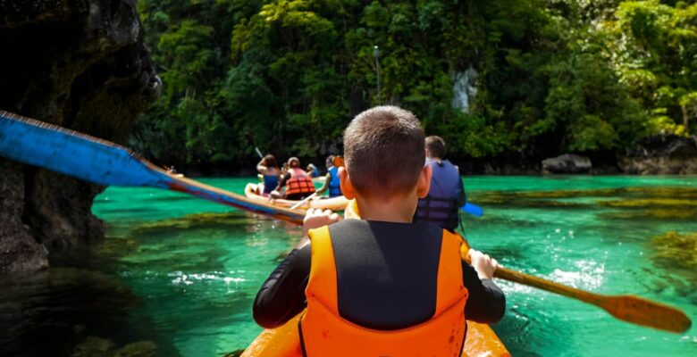 child wearing life jacket in kayak