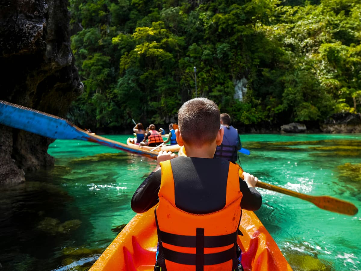 child wearing life jacket in kayak