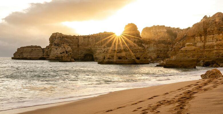 algarve beach with sunset behind rocks