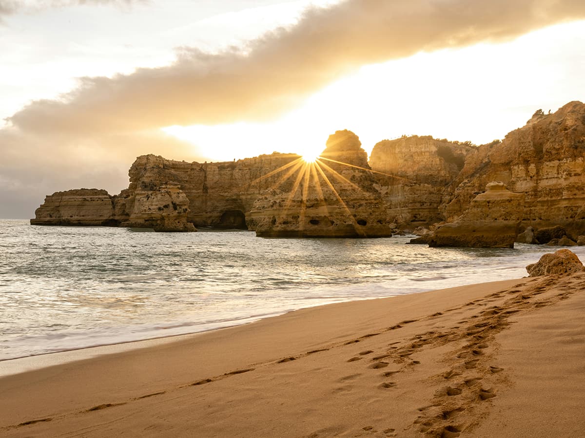 algarve beach with sunset behind rocks