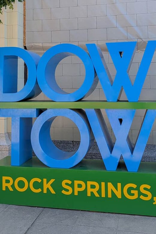 downtown rock springs sign with woman leaning on it