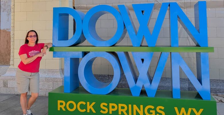 downtown rock springs sign with woman leaning on it