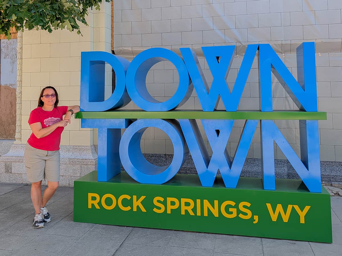 downtown rock springs sign with woman leaning on it