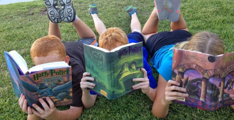 boys reading outdoors on the grass
