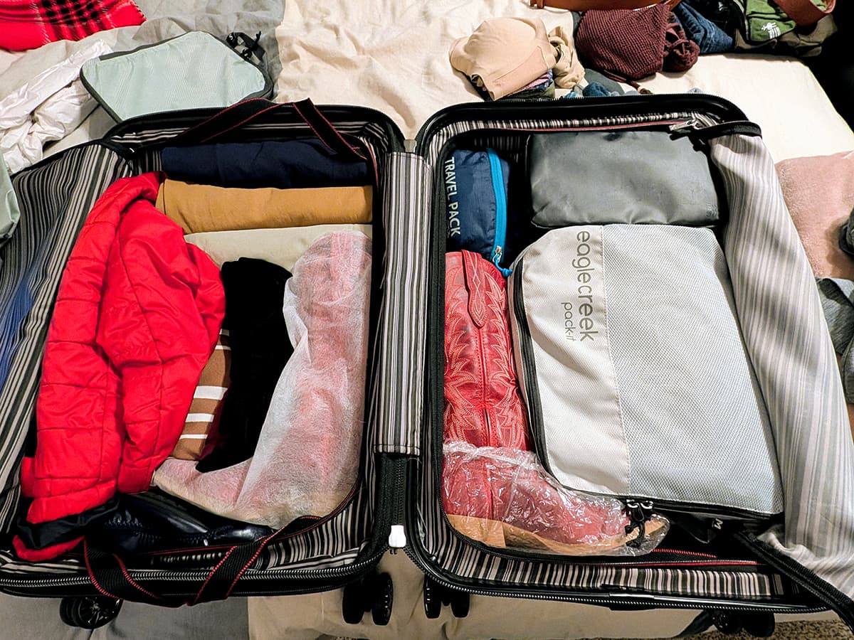 packed suitcase with boots