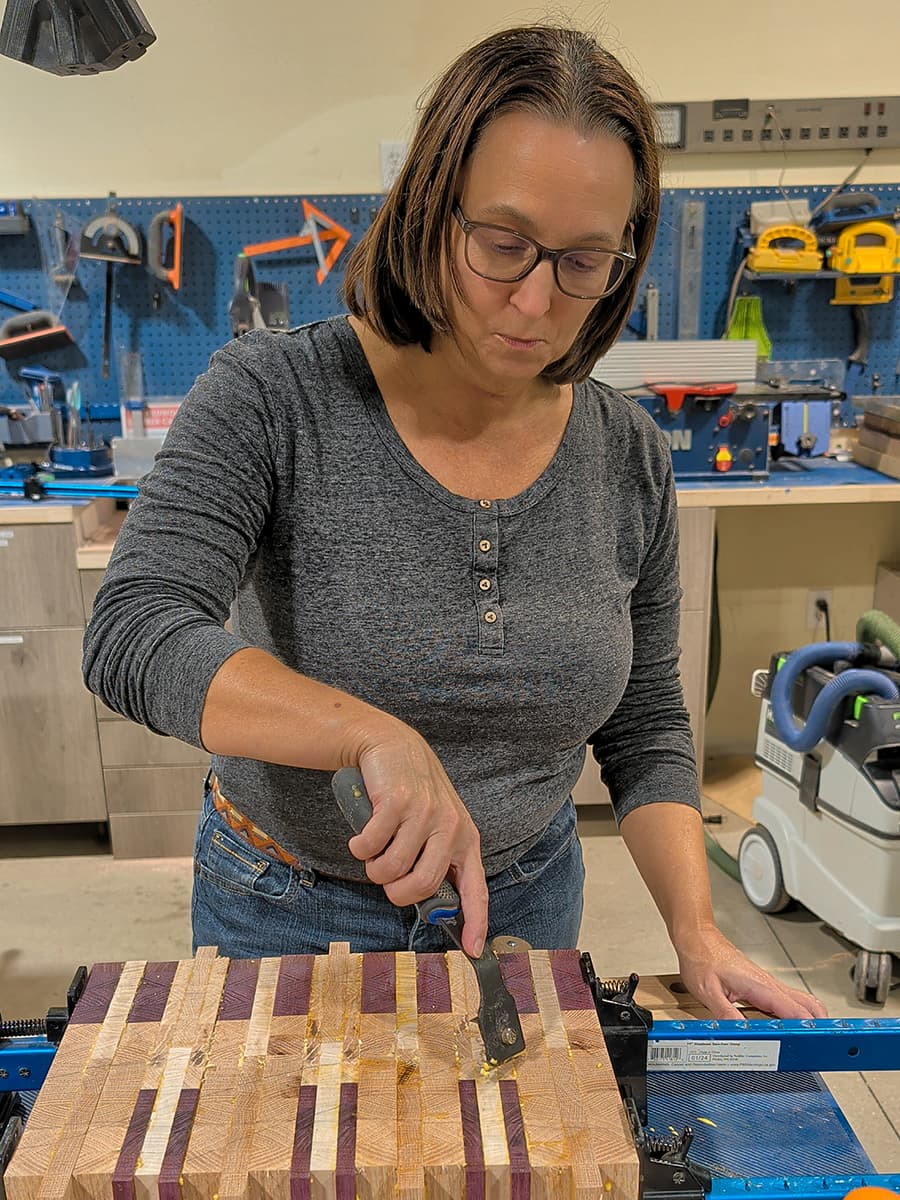 woman gluing together a cutting board